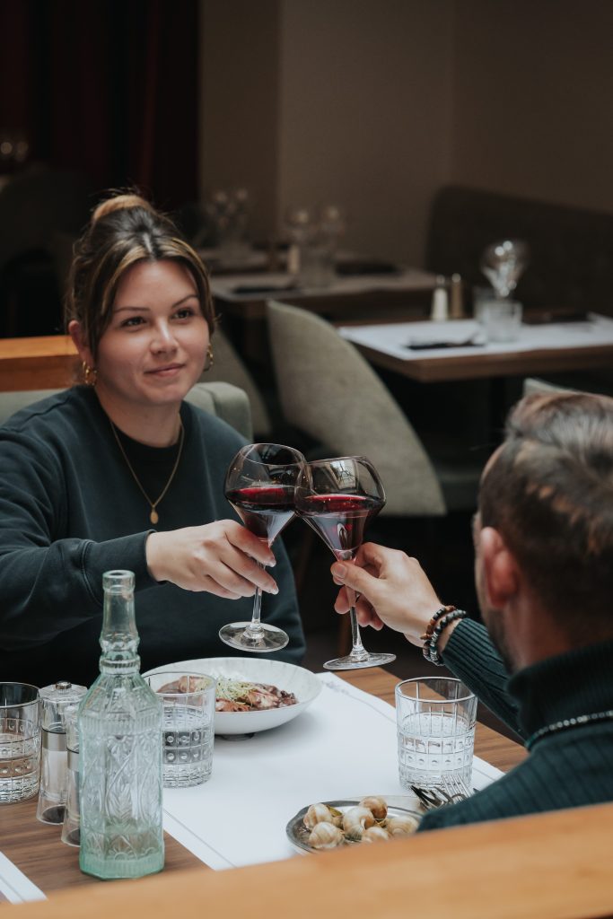 Clients attablés autour d'un verre de vin rouge au Monge
